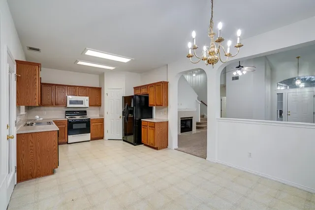 an open kitchen with stainless steel appliances kitchen island a refrigerator and a stove top oven