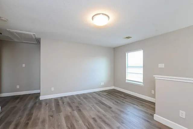 wooden floor in an empty room with a fan