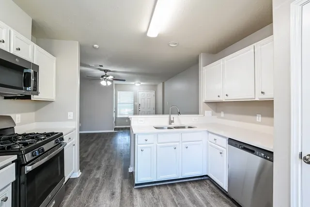 a kitchen with sink a microwave and cabinets