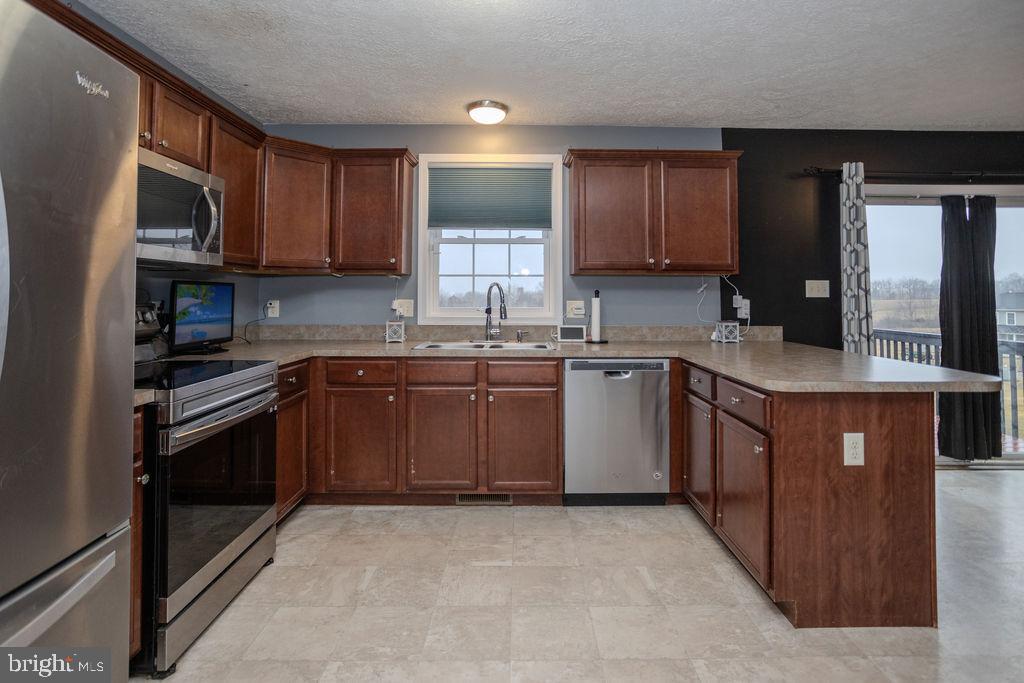 4482 Fort McCord Road Chambersburg, PA 17202 - Photo 15 of 47 a kitchen with stainless steel appliances granite countertop a sink stove cabinets and refrigerator