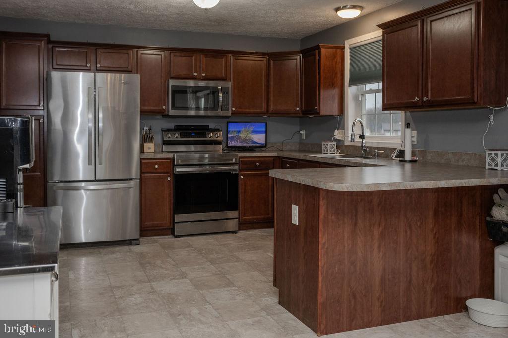 4482 Fort McCord Road Chambersburg, PA 17202 - Photo 17 of 47 a kitchen with stainless steel appliances granite countertop a stove a refrigerator and a sink