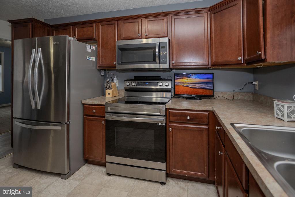 4482 Fort McCord Road Chambersburg, PA 17202 - Photo 18 of 47 a kitchen with a refrigerator stove and microwave