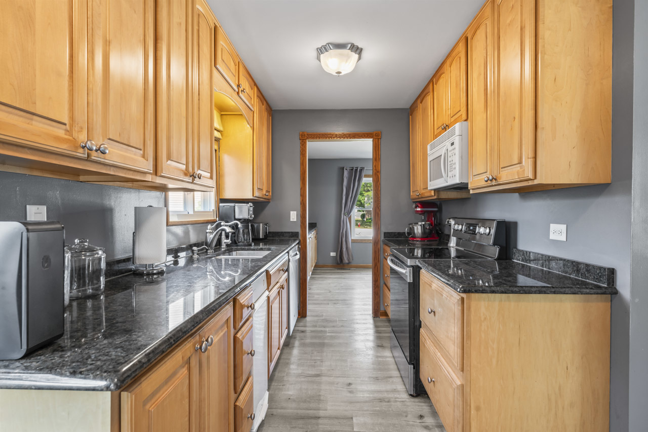 34 Spring Valley Lane Streamwood, IL 60107 - Photo 5 of 24 a kitchen with stainless steel appliances granite countertop a sink a stove and cabinets
