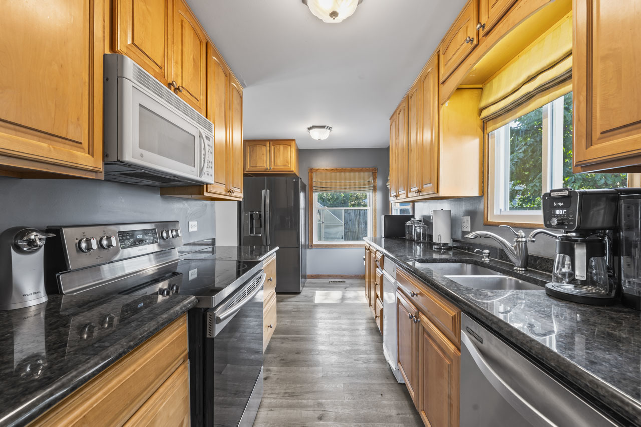 34 Spring Valley Lane Streamwood, IL 60107 - Photo 6 of 24 a kitchen with stainless steel appliances granite countertop a stove a sink and a microwave