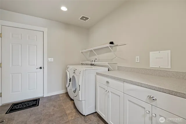 a utility room with cabinets washer and dryer
