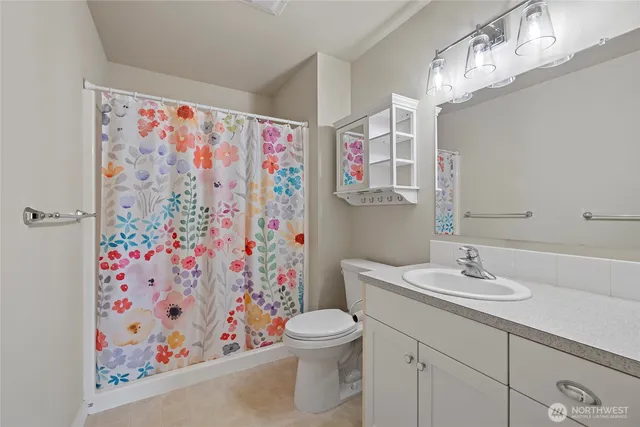 a bathroom with a sink a toilet and shower curtain