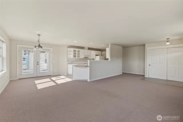 a view of an empty room with a cabinet and a window