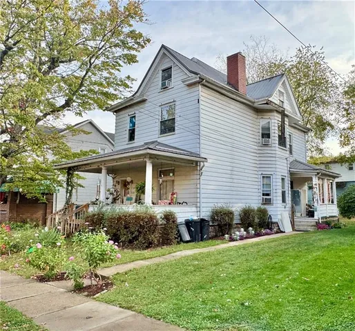 a front view of a house with a yard and potted plants