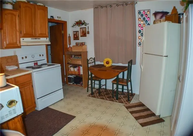 a kitchen with a refrigerator and a stove top oven