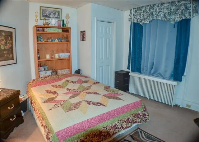 a bed sitting in a bedroom next to a wooden cabinet