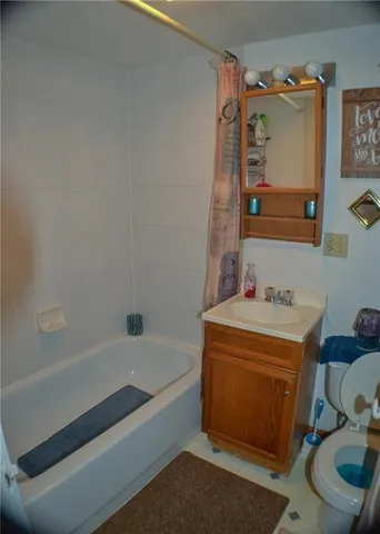 a bathroom with a tub sink and mirror