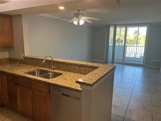 a kitchen with a sink a granite counter top and a chandelier