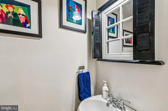 a bathroom with a toilet and a picture on the wall