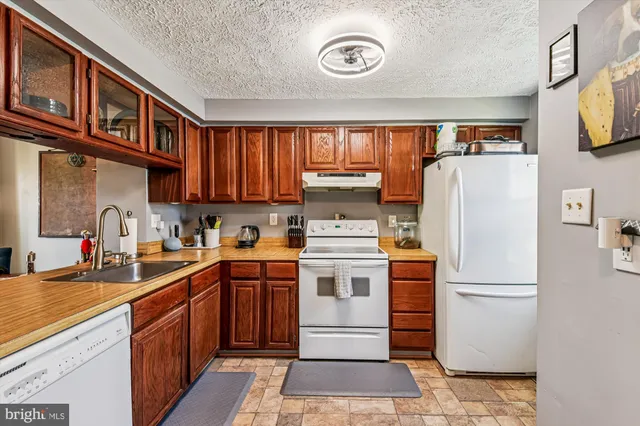 a kitchen with stainless steel appliances granite countertop a refrigerator a stove a sink and a microwave