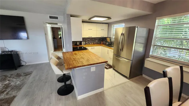 a kitchen with stainless steel appliances granite countertop a refrigerator and a sink