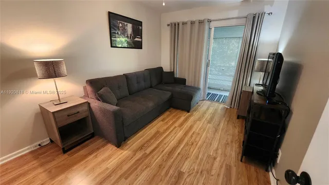 a bedroom with a bed a flat screen tv and windows