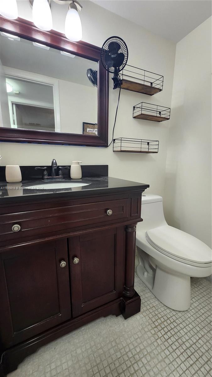 253 Prescott M, Unit 253 Deerfield Beach, FL 33442 - Photo 19 of 53 a bathroom with a toilet a sink and mirror
