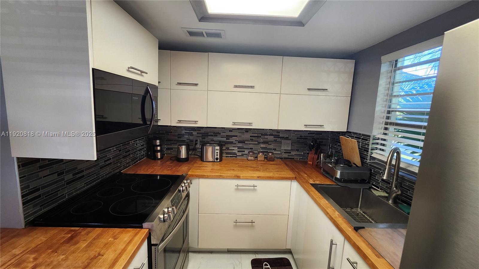 253 Prescott M, Unit 253 Deerfield Beach, FL 33442 - Photo 3 of 53 a kitchen with a sink a stove and cabinets