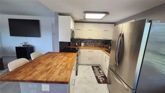 a kitchen with granite countertop a refrigerator and a sink