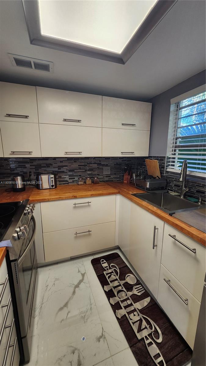 253 Prescott M, Unit 253 Deerfield Beach, FL 33442 - Photo 6 of 53 a kitchen with a sink a stove and cabinets