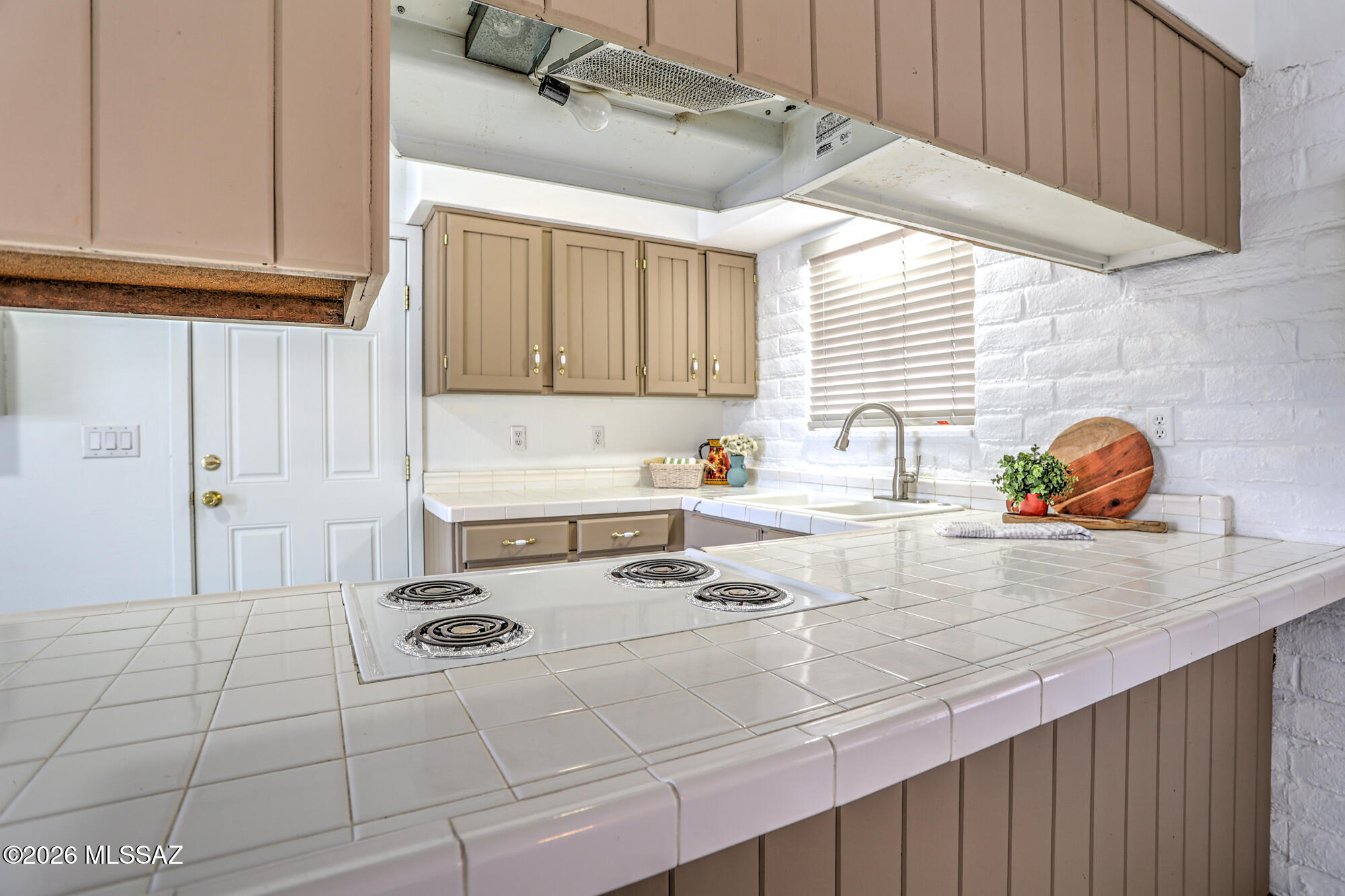 4400 West Ina Road Tucson, AZ 85741 - Photo 17 of 43 a kitchen with a sink a stove cabinets and a counter top space
