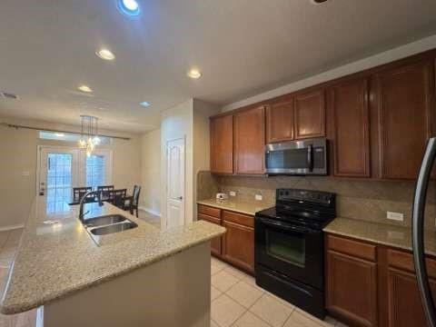 5820 Stone Mountain Road The Colony, TX 75056 - Photo 12 of 27 a kitchen with stainless steel appliances granite countertop a sink stove and microwave