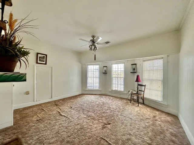 a view of a room with a chandelier fan and a window