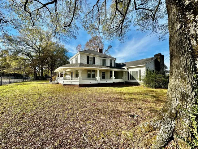 a view of a street with a building and trees in the background
