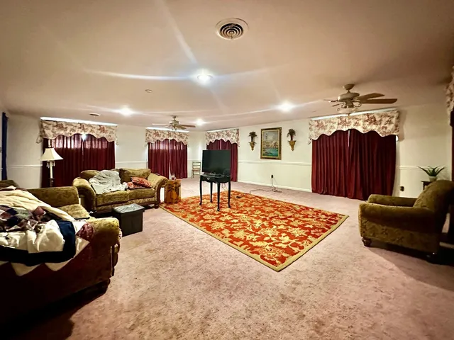 a spacious bedroom with a bed a couch and a mirror