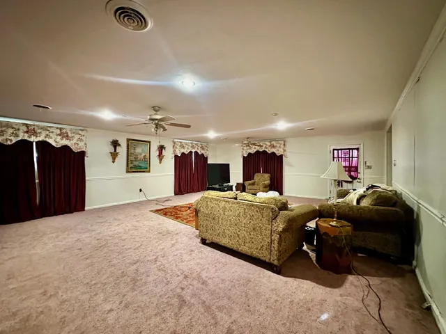 a view of empty room with ceiling fan and window