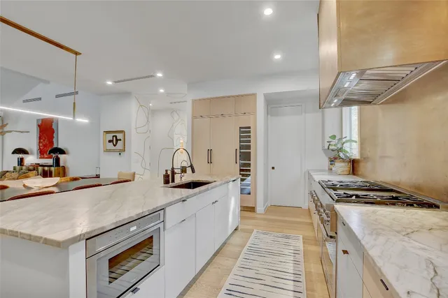 a kitchen with granite countertop a sink stove and cabinets