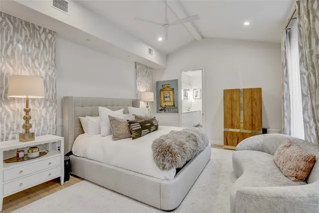 a bedroom with a large bed and wooden floor