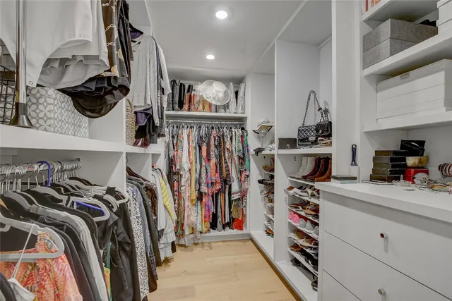 a view of walk in closet with clothes and shoes
