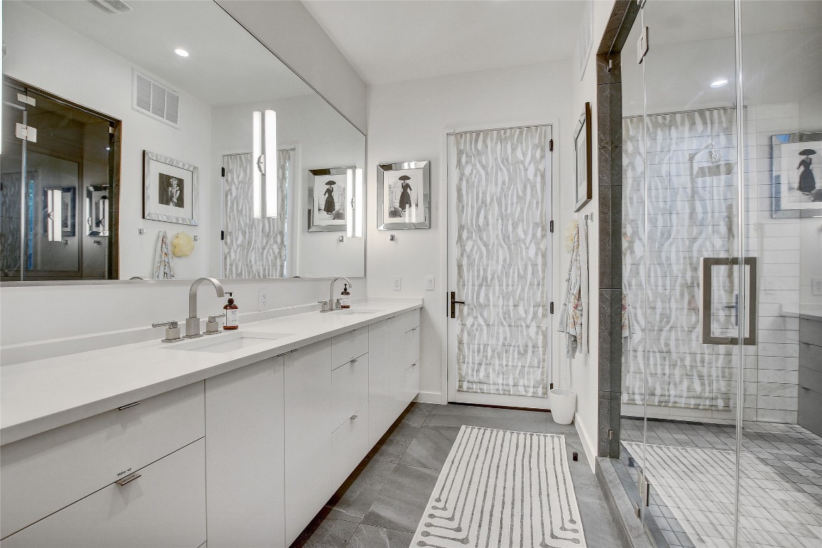 2006 Ford Street Austin, TX 78704 - Photo 17 of 40 Full bath featuring double vanity, a stall shower, recessed lighting, and dark tile patterned floors