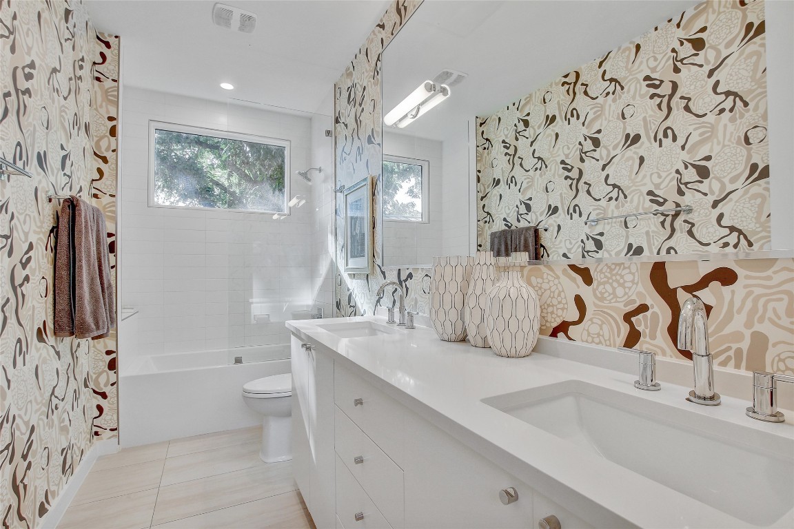 2006 Ford Street Austin, TX 78704 - Photo 32 of 40 Full bath on second floor featuring wallpapered walls, double vanity, bathtub / shower combination, and light tile patterned flooring