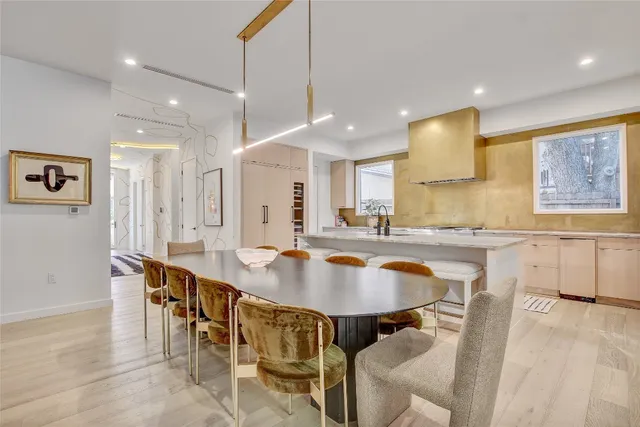 a kitchen with a dining table chairs sink and cabinets