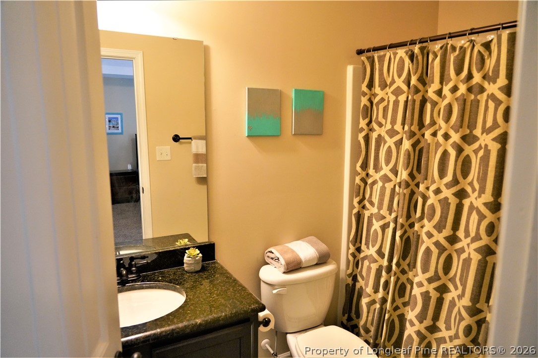 930 Old Vander Road Fayetteville, NC 28312 - Photo 31 of 45 a bathroom with a granite countertop toilet sink and mirror