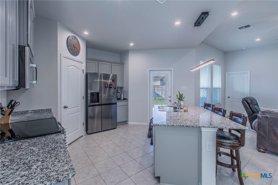 908 Coriander Road Temple, TX 76501 - Photo 8 of 28 a kitchen with kitchen island a counter top space cabinets and stainless steel appliances