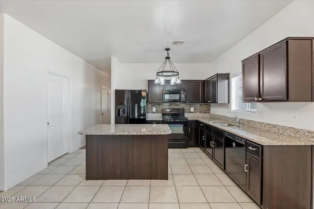 a kitchen with stainless steel appliances granite countertop a sink dishwasher stove and refrigerator