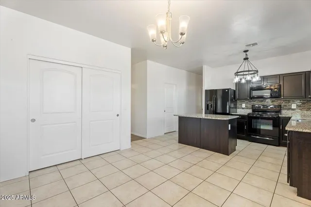 a large kitchen with granite countertop lots of counter top space and stainless steel appliances