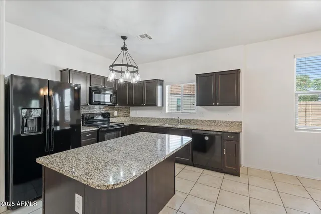 a kitchen with granite countertop a sink and refrigerator