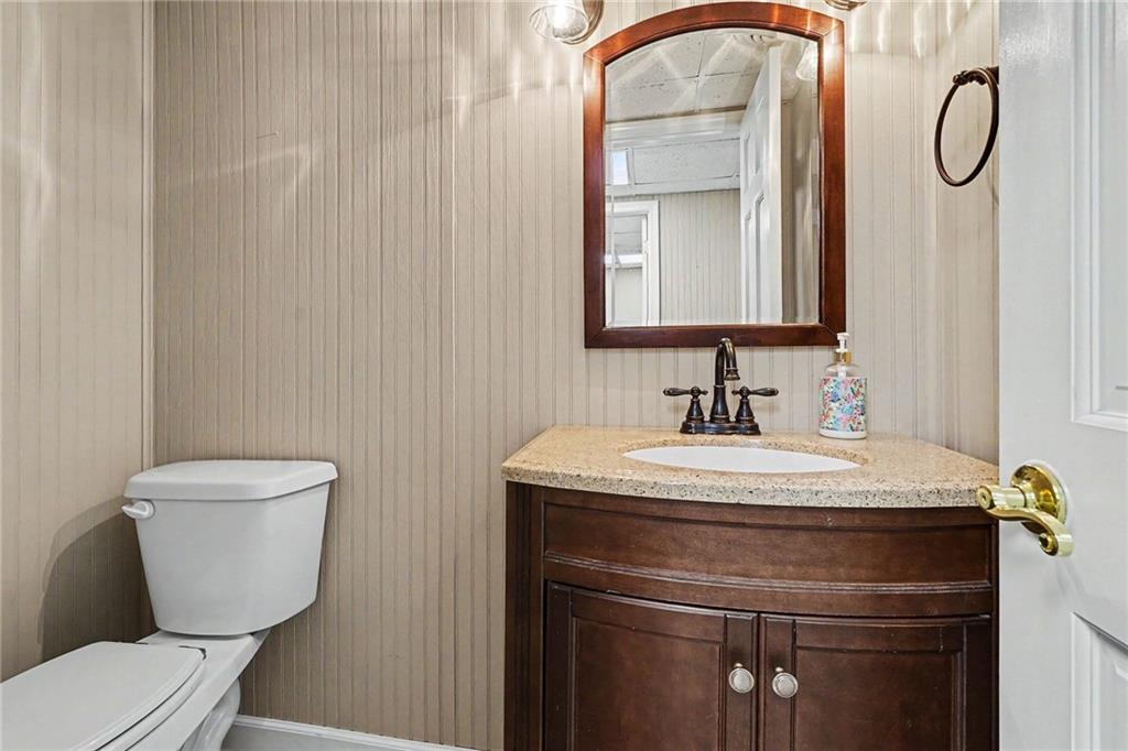 740 Smyrna Road Southwest Conyers, GA 30094 - Photo 11 of 27 a bathroom with a granite countertop toilet sink and mirror