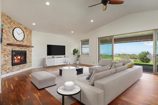 a living room with furniture fireplace and a large window