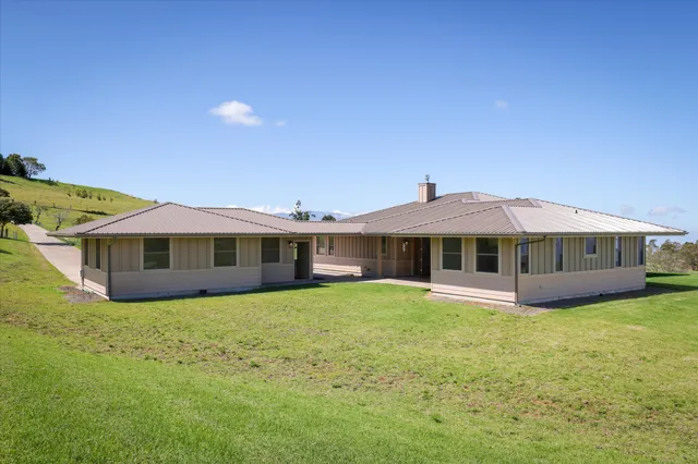 a view of a house with a yard and sitting area