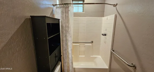 a bathroom with a shower and a mirror