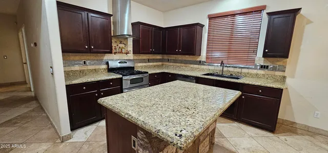 a kitchen with granite countertop wooden cabinets and a sink