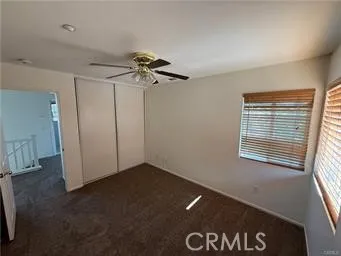 a view of a livingroom with a ceiling fan and window