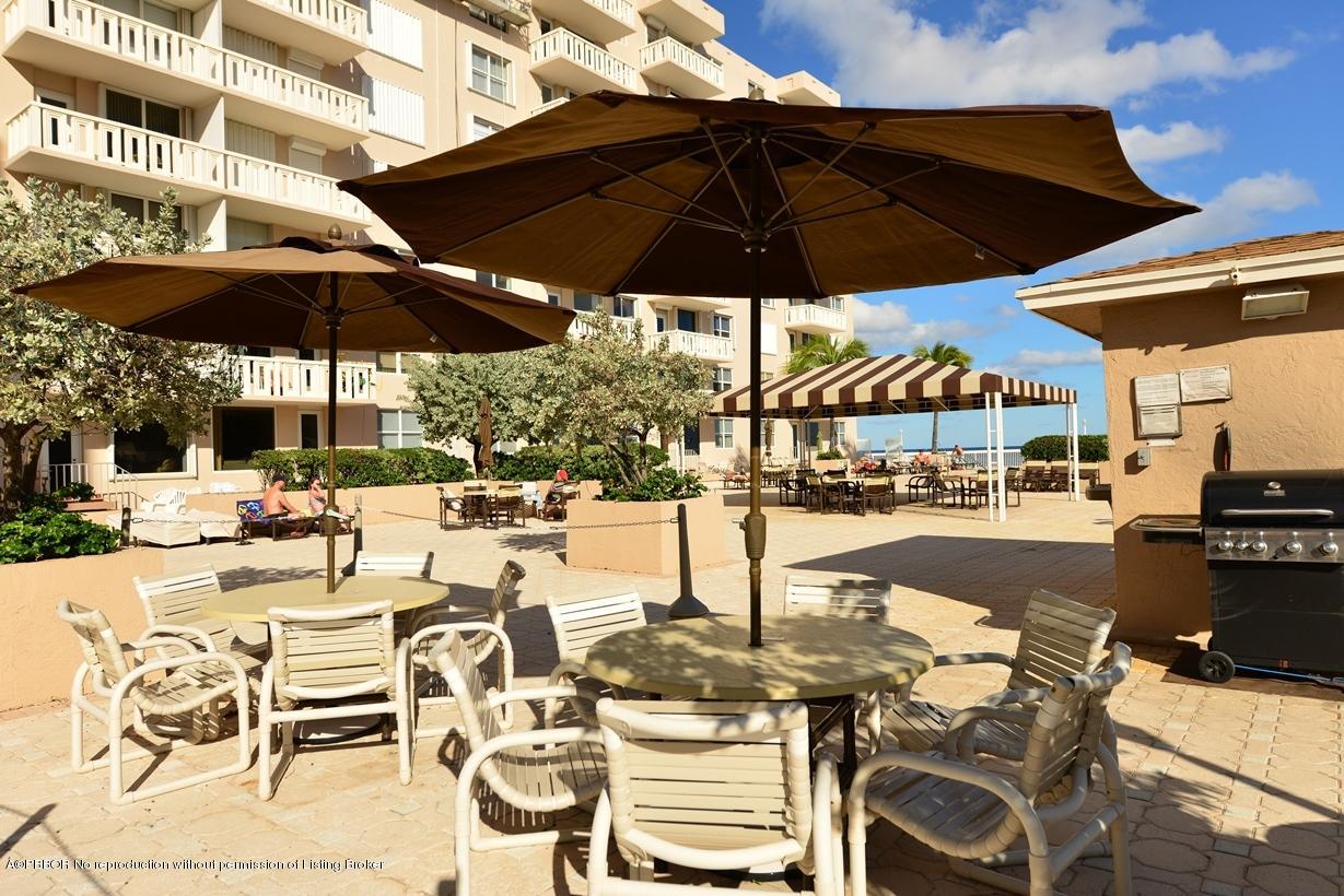 3450 South Ocean Boulevard, Unit 410 Palm Beach, FL 33480 - Photo 18 of 21 a view of a patio with a table and chairs under an umbrella