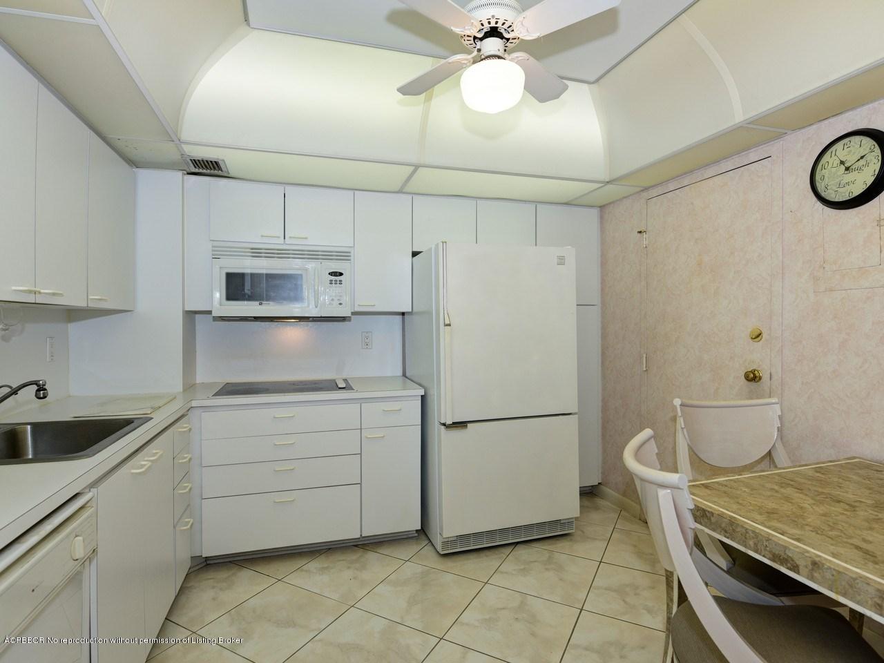 3450 South Ocean Boulevard, Unit 410 Palm Beach, FL 33480 - Photo 5 of 21 a kitchen with white cabinets and white appliances