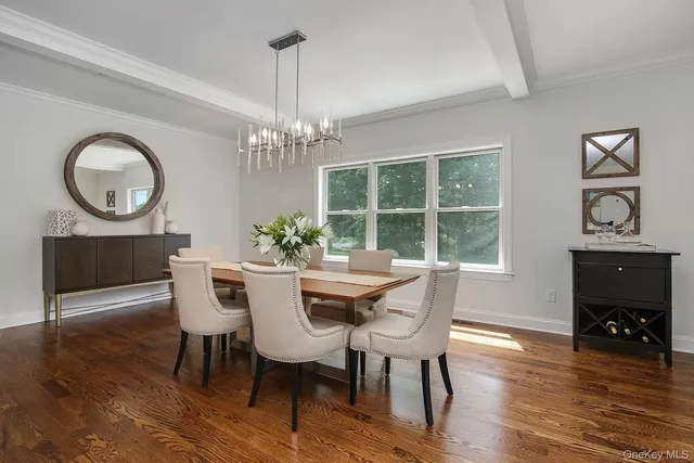 a dining room with furniture a chandelier and wooden floor